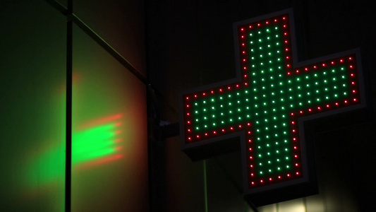 街上霓虹灯效果的药房十字标志灯闪烁在夜间视频