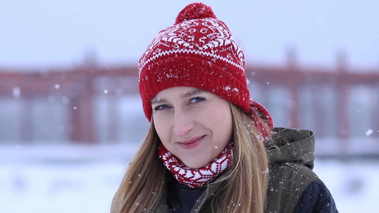 冬季飘雪站在户外微笑的年轻女人视频