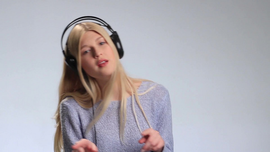年轻女人戴着耳机听音乐[二十多岁]视频