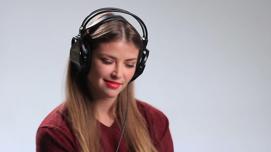 戴着耳机在听音乐的漂亮女孩在享受着美妙音乐表情特写视频