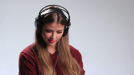 女孩戴着耳机听音乐[戴起]视频