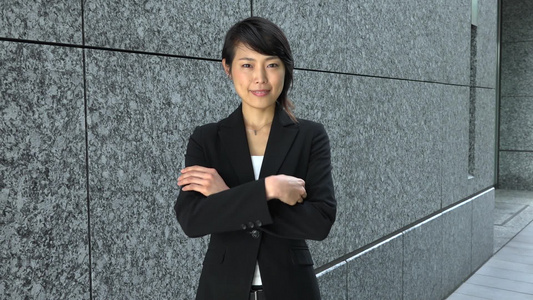 快乐漂亮的日本女经理自信地交叉着手看向相机的肖像视频