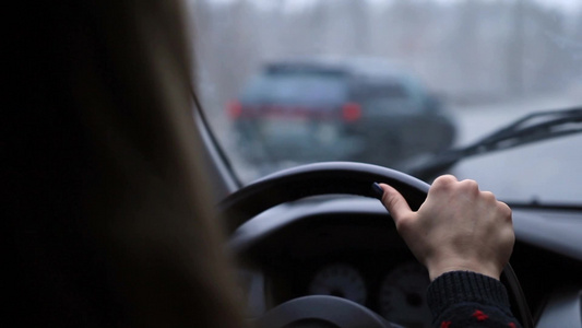 年轻的女司机在冬天的高速公路上驾驶汽车视频