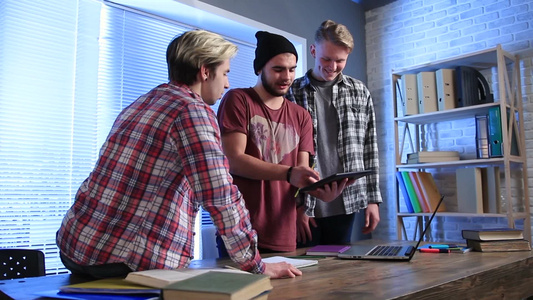 一群自由职业者站在办公桌前使用平板电脑交流他们的设计方案[待业者]视频