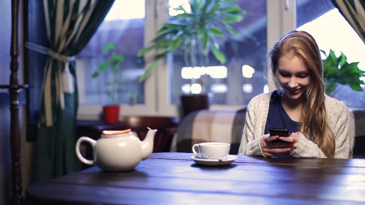 咖啡店喝茶玩手机的女人视频