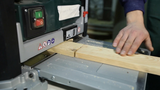 木匠把木制木板放在电动刨床上使表面光滑视频