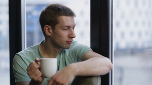年轻人坐在窗边喝着咖啡看向外面的风景13秒视频