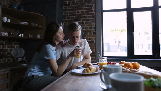 年轻男女在厨房里用吸管喝梅森罐子里的橙汁视频