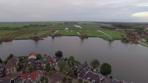 空中拍摄荷兰水边风车和绿色田野56秒视频