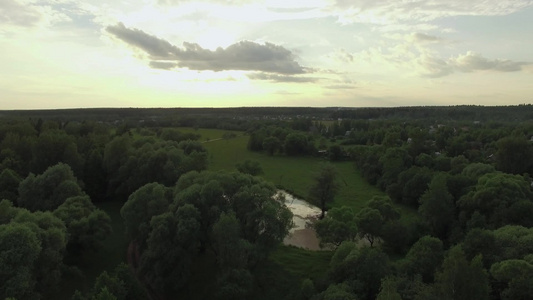 日落时空中拍摄绿色森林和村庄视频