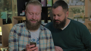 两个成熟的有胡须的男人在手机上浏览网页8秒视频