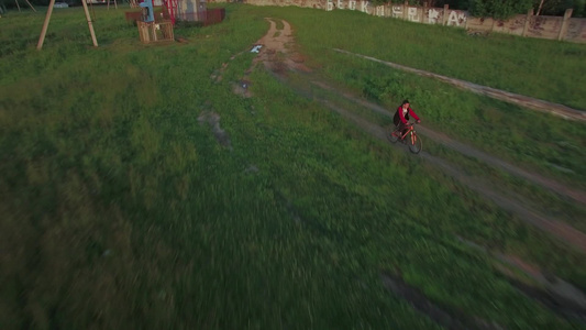 男孩沿乡村道路骑自行车视频