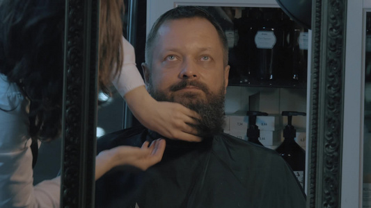 女理发师给中年男性涂胡子化妆品视频