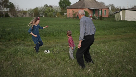 祖父陪孩子踢足球视频