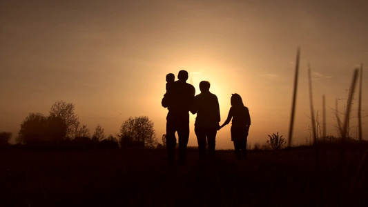 爸爸妈妈和儿子女儿在一起享受夕阳的美好时光背影视频