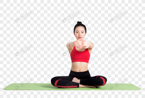 坐在瑜伽垫上做伸展运动的女性图片