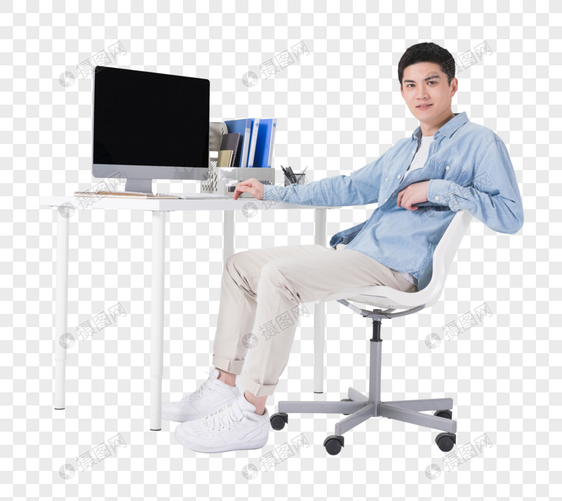 年轻男性坐在办公桌前工作图片