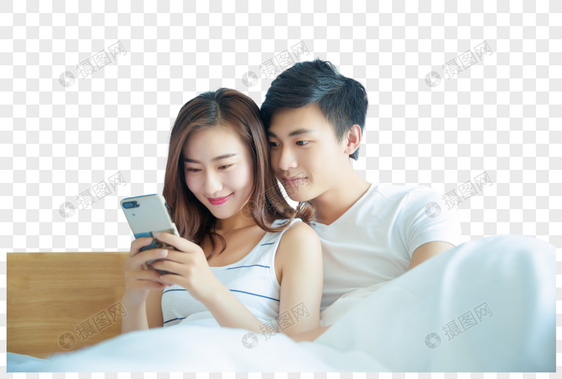 年轻情侣在床上看手机图片