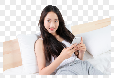 美女坐在床上玩手机图片