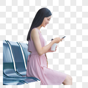 坐在公交站台玩手机的女性图片