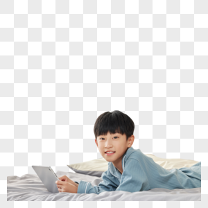 在床上玩平板电脑的小男孩图片