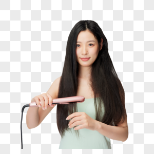 年轻女性使用夹板拉直头发高清图片