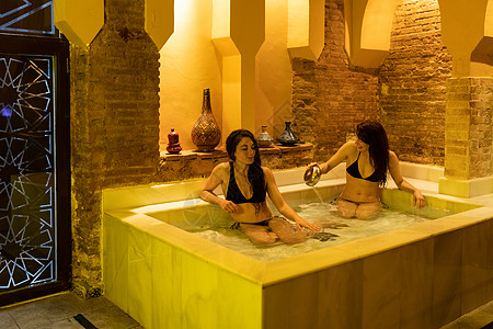 两名妇女西牙格拉纳达安达卢西亚享受阿拉伯浴埃尔维拉浴冷水池两个女人格拉纳达享受阿拉伯浴图片
