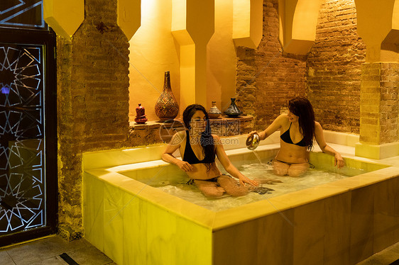 两名妇女西牙格拉纳达安达卢西亚享受阿拉伯浴埃尔维拉浴冷水池两个女人格拉纳达享受阿拉伯浴图片