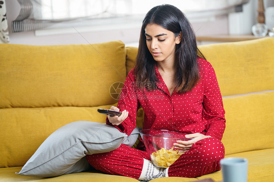 波斯女人家看电视用遥控器女孩吃土豆片波斯女人家看电视用遥控器图片