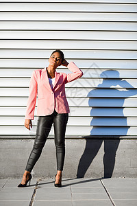 黑人女人,时尚模特,站城市墙上非裔美国女性穿着粉红色夹克日落灯黑人女性,站城市墙上图片