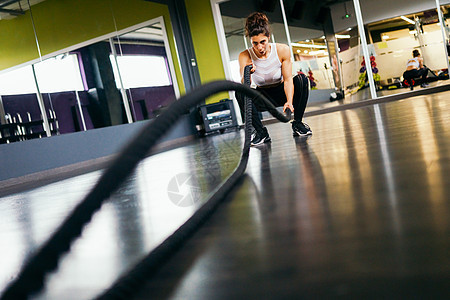 年轻运动的女人健身房用训练绳健身年轻运动的女人健身房用训练绳图片