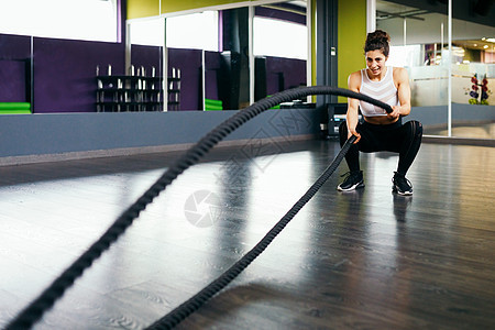 年轻运动的女人健身房用训练绳健身年轻运动的女人健身房用训练绳图片