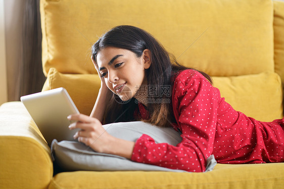 波斯女人家用数字平板电脑沙发上波斯妇女家用数字平板电脑图片