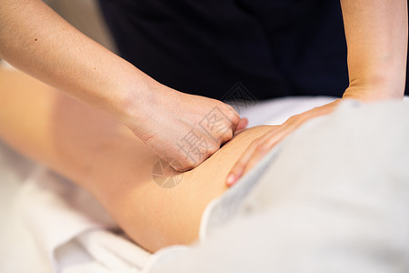 理疗中心腿部的医疗按摩女性理疗师检查她的病人理疗中心的腿部进行医疗按摩背景图片