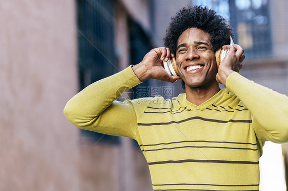 黑色男子与AFR头发听音乐与无线耳机观光格拉纳达,安达卢西亚,西牙黑人听音乐与无线耳机观光格拉纳达图片