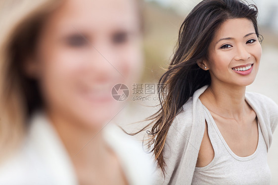户外轮廓肖像,个美丽的微笑快乐的中国亚洲年轻妇女或女孩与金发女性朋友海滩图片