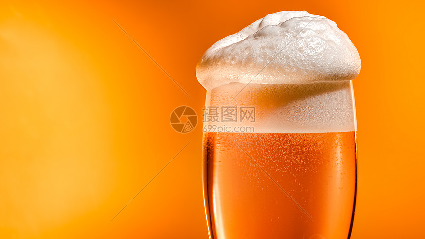 啤酒落玻璃杯里,有顶白色的泡沫帽图片