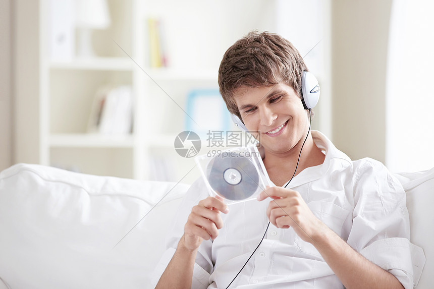 ‘~个带着耳机音乐CD的年轻人手中  ~’ 的图片