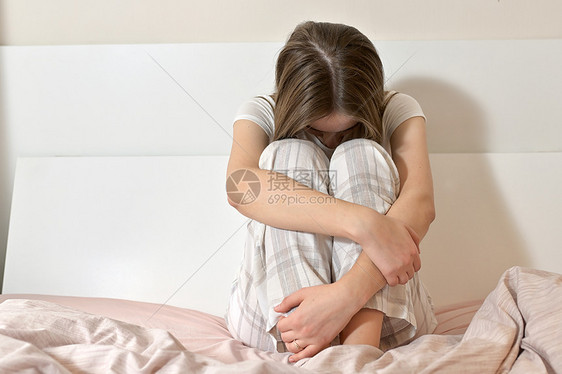 早上坐床上的悲伤女人图片