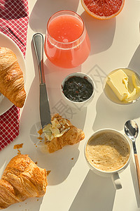早餐,白色桌子上有咖啡果汁牛角面包图片