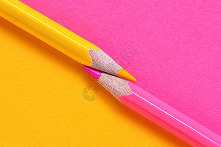 黄色粉红色的蜡笔同纸背景上图片