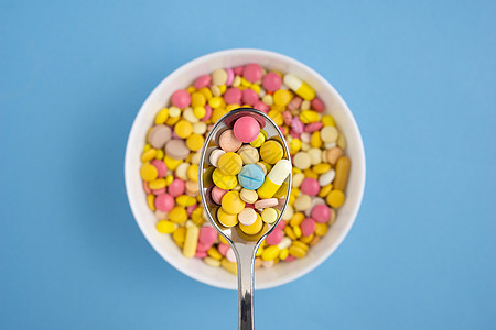 创意健康饮食医学照片的药丸药物盘子与勺子蓝色背景你吃什么图片