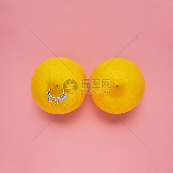 创意食品健康时尚照片柠檬形状的女性乳房与乳头穿孔粉红色背景图片