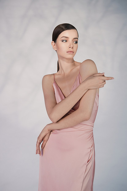 穿着优雅时尚连衣裙的女人穿着粉红色晚礼服工作室里摆着漂亮的模特