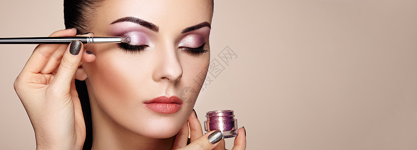 化妆师应用眼影漂亮的女人脸完美的妆容化妆细节美丽的女孩有完美的皮肤指甲指甲图片