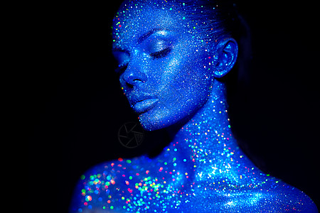 时尚模特女人穿着蓝色明亮的火花霓虹灯工作室摆姿势美丽性感女人的肖像艺术彩色闪光发光化妆图片