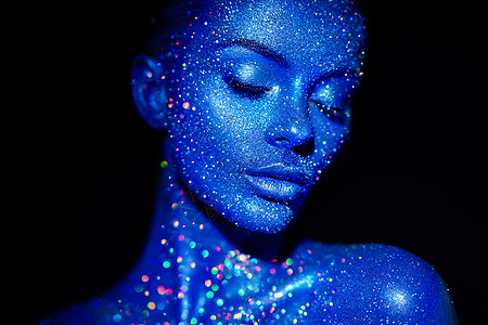 时尚模特女人穿着蓝色明亮的火花霓虹灯工作室摆姿势美丽性感女人的肖像艺术彩色闪光发光化妆图片