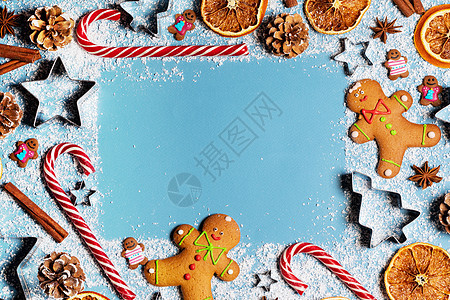 圣诞食品姜饼饼干焦糖糖果甘蔗肉桂模具形状八角橙片蓝色背景与圣诞食品背景图片