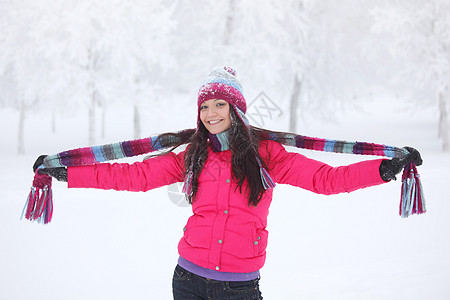 快乐的微笑女孩穿着粉红色的衣服,冬天的公园玩得很开心冬天公园里的快乐女孩图片