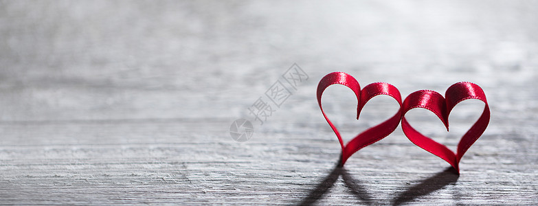 两个红色丝带的心木制背景上与的文本,情人节的红色丝带的心木头上图片